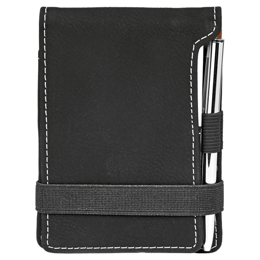A black synthetic leatherette mini notepad with a pen