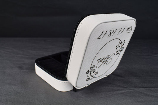 a white leatherette jewelry box opened to display a black interior, featuring a laser engraving on the lid