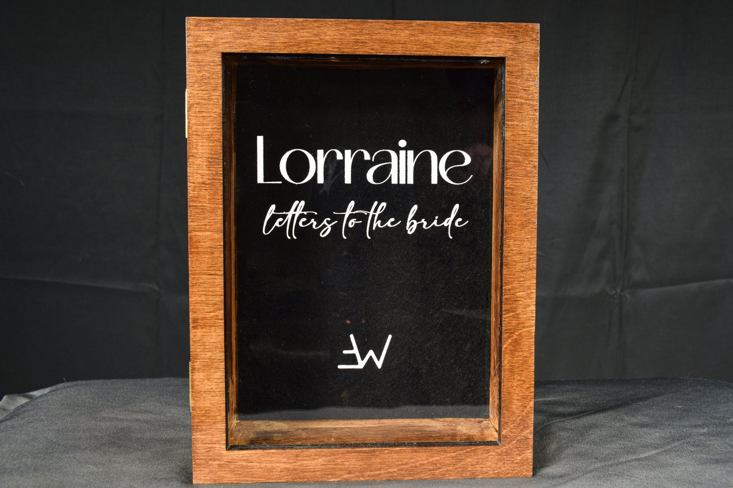 A handcrafted wooden letter box with a clear customizable acrylic face plate featuring the text 'Lorraine letters to the bride' in white.