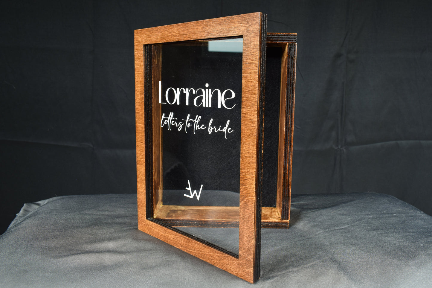 A handcrafted wooden letter box showcasing the hinged lid and clear cover, featuring a custom engraving of 'Lorraine letters to the bride' in white