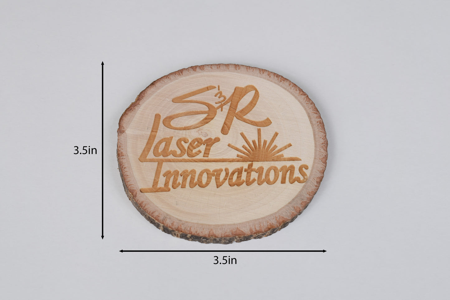 a round basswood coaster on a white background with size markers