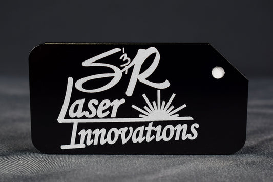A black aluminum luggage tag with the 'S&R Laser Innovations' logo laser engraved on the front