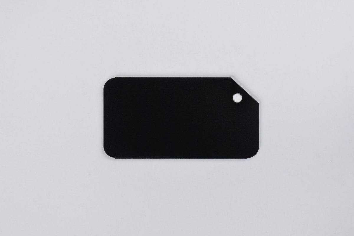 A black aluminum luggage tag on a white background