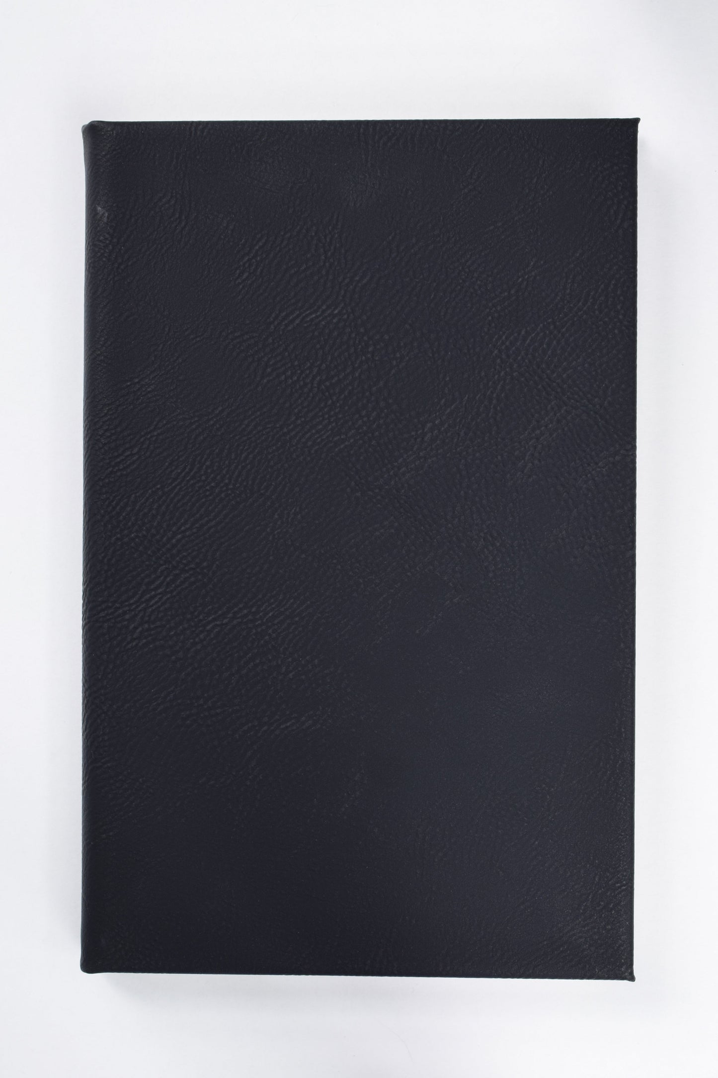 a black leatherette journal lying on a white surface