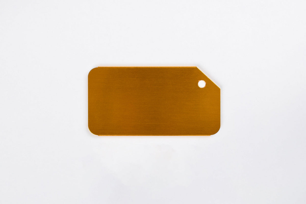 A gold aluminum luggage tag on a white background