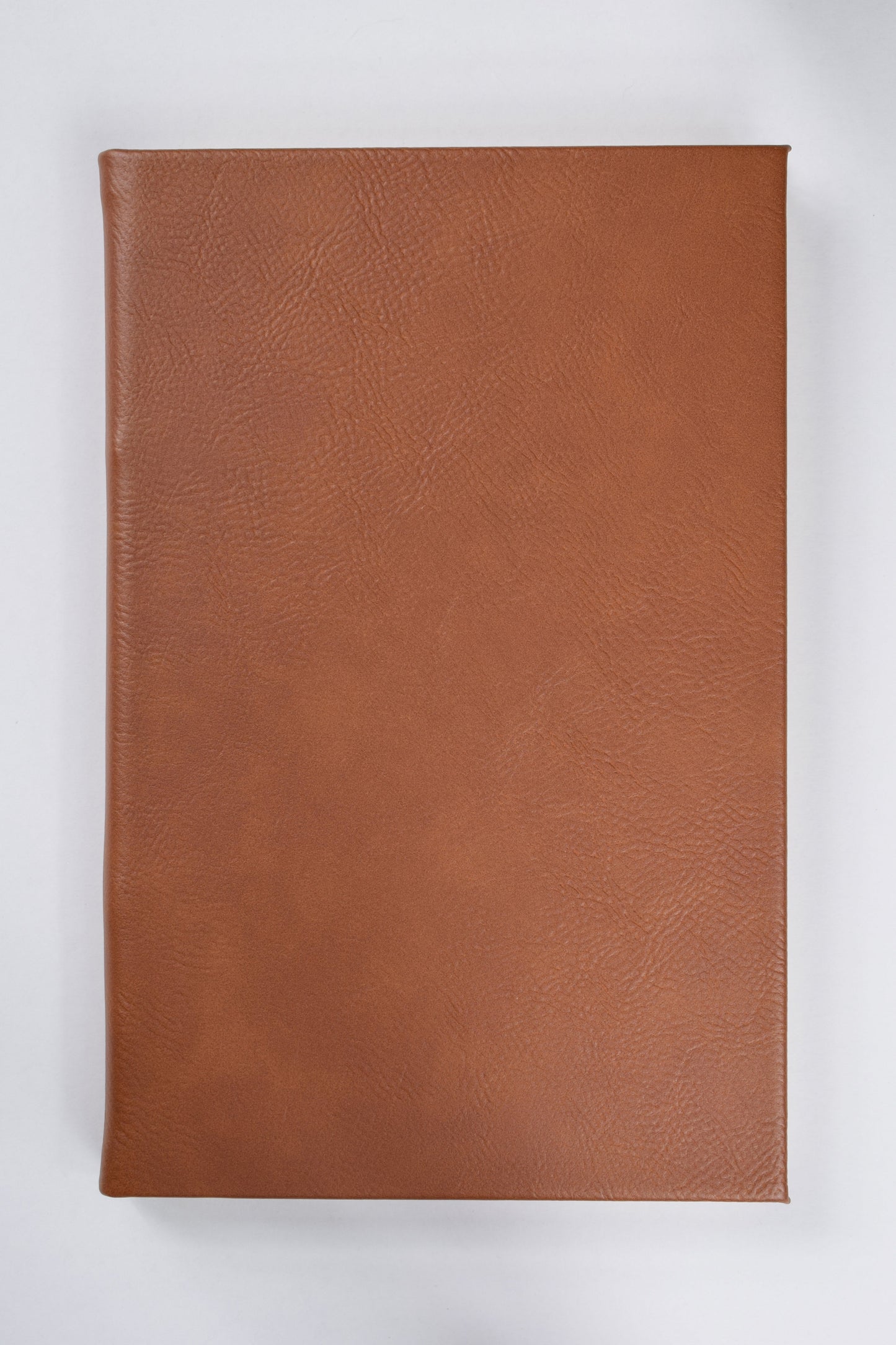 a rawhide brown leatherette journal lying on a white surface