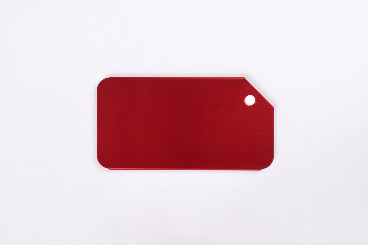 A collection of custom engraved aluminum luggage tags in various colors, each featuring a silver/gray engraved text.