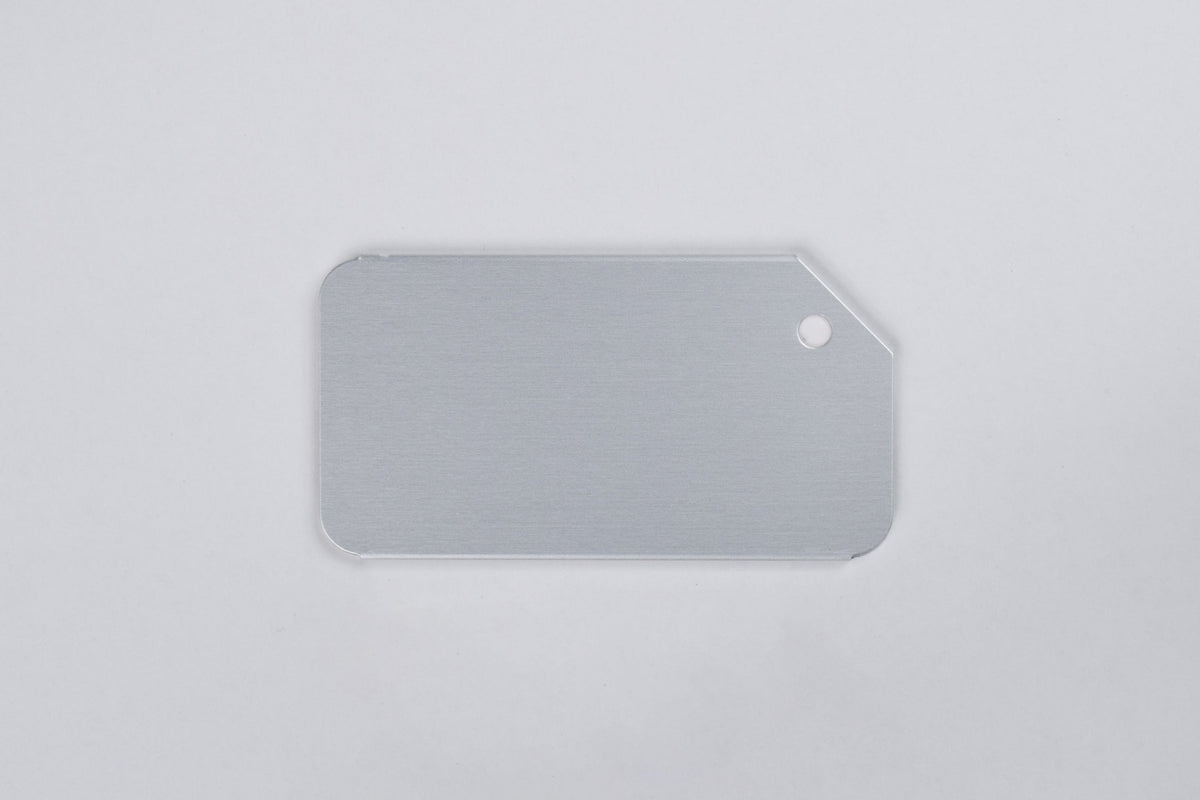a silver aluminum luggage tag on a white background