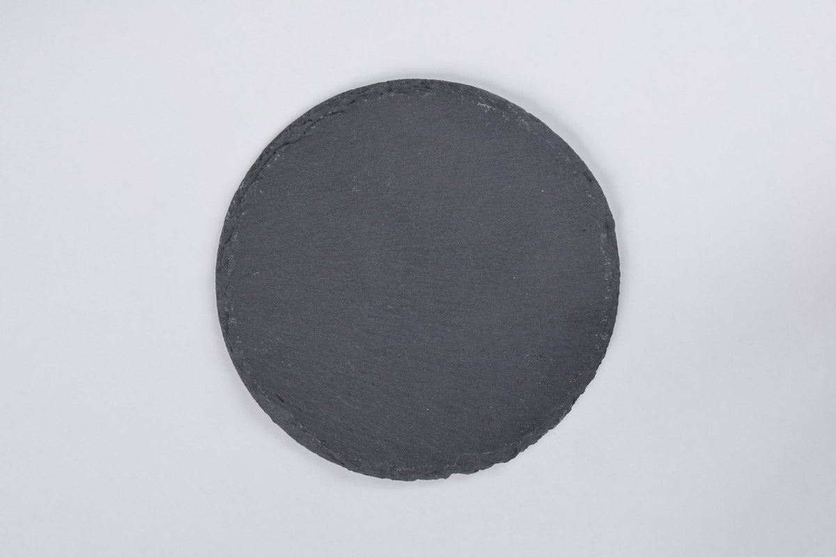 A round black slate coaster displayed on a white background