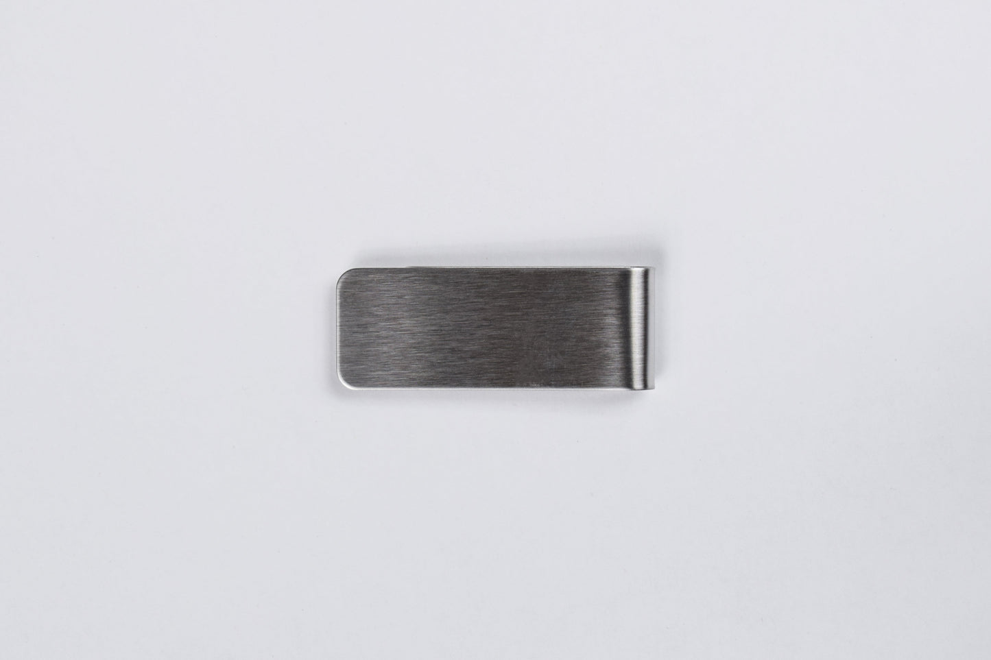 A stainless steel money clip with a brushed finish on a white background.