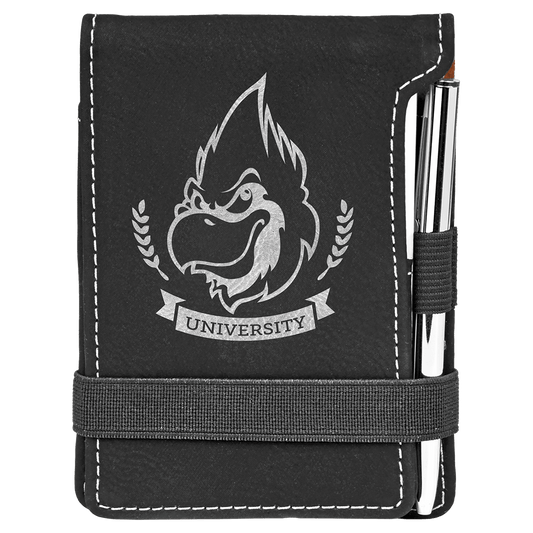 A black synthetic leatherette mini notepad with a pen, featuring custom engraving of a university logo on the cover.