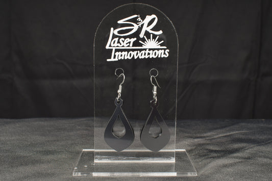 a pair of teardrop shaped hoop style earrings in charcoal metallic acrylic displayed on a clear stand with the 'S&R Laser Innovations' logo on top