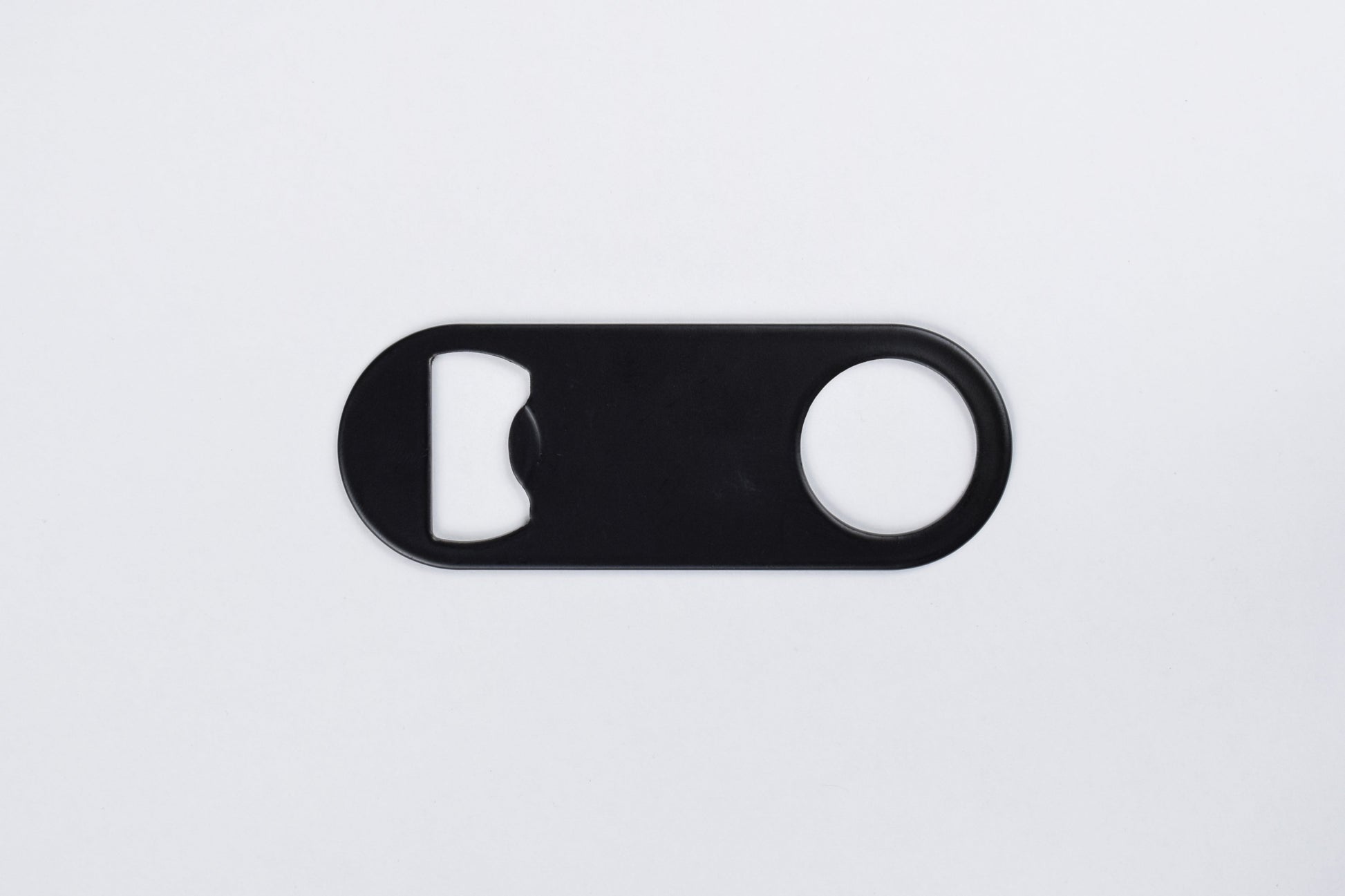 A black stainless steel bottle opener keychain with no key ring, displayed against a white background.