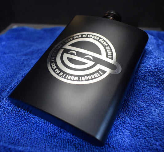 a black flask with a circular laughing man logo laser engraved on the front