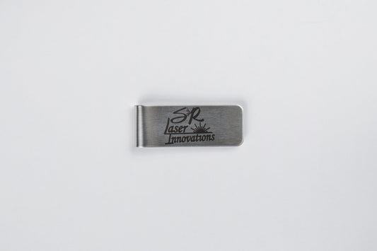 A stainless steel money clip with custom logo engraving, laid out on a white background.